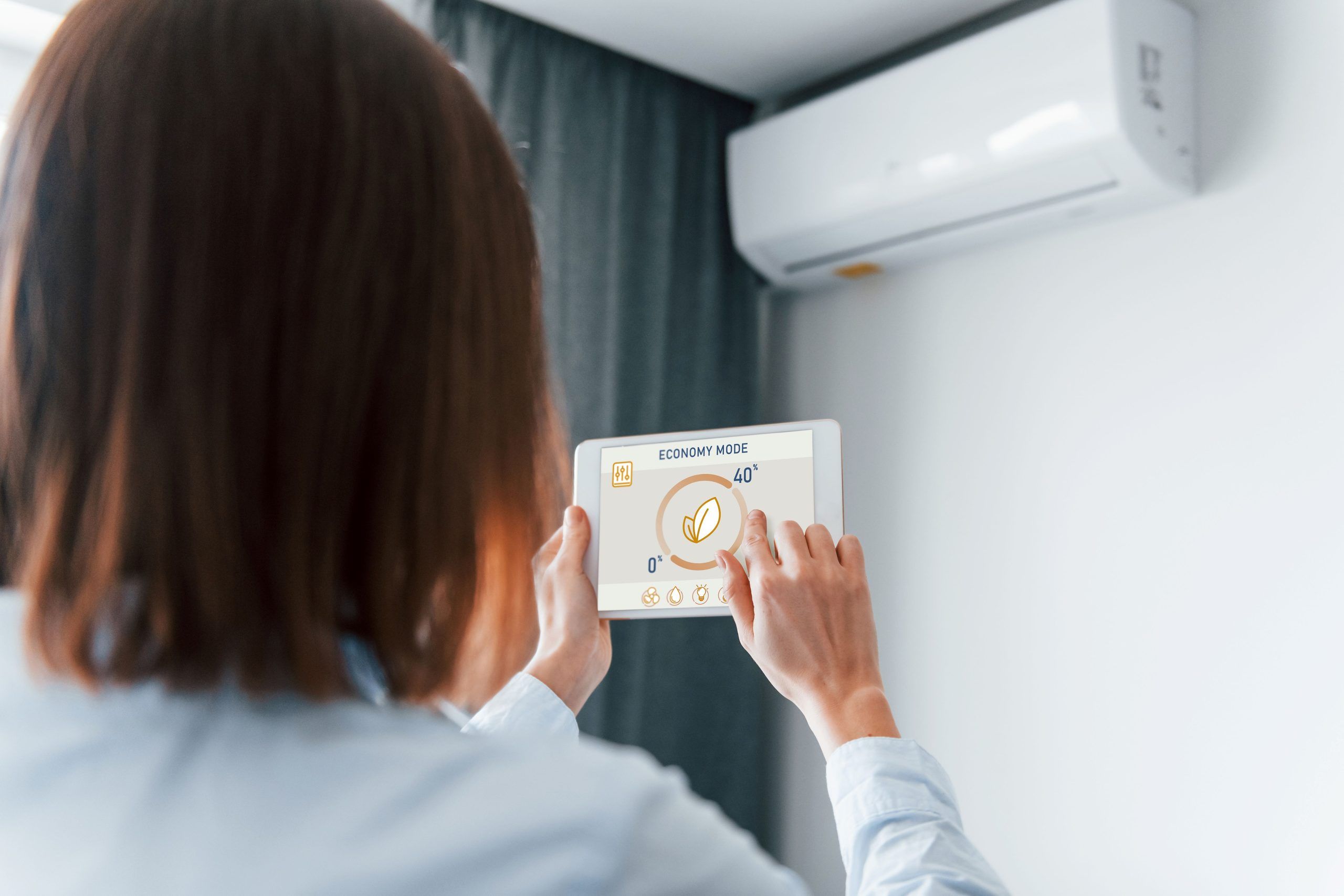 woman using AC zoning system at home